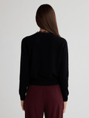Close-up of black cashmere cardigan with delicate lace-trimmed crew neckline
